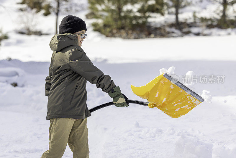 男孩在家里铲雪