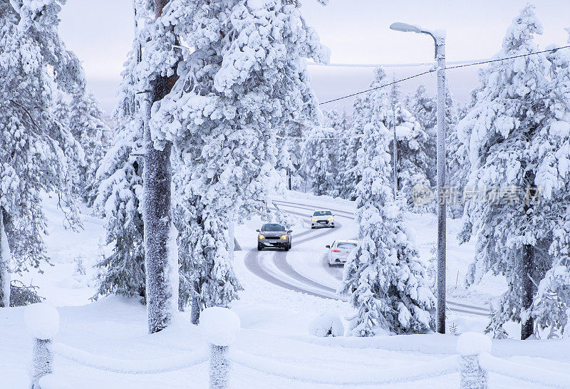 白雪覆盖的森林和乡村白雪覆盖的道路。汽车在雪地里行驶。