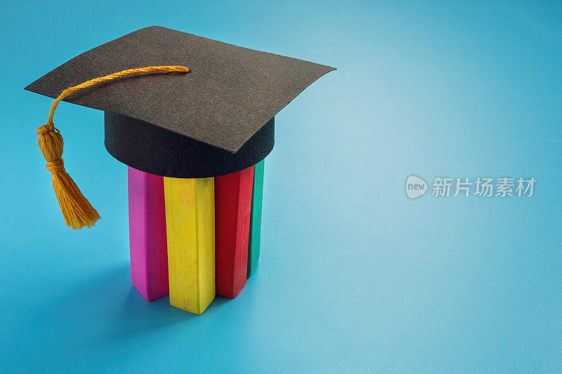 包容和神经多样性教育。戴着毕业帽的彩色蜡笔。