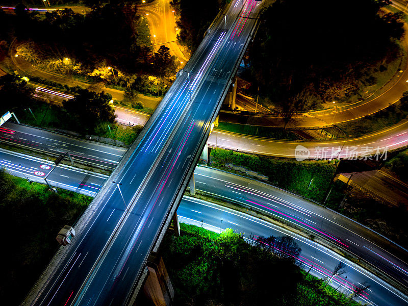 空中无人机的天空视图拍摄的交通在里斯本在夜间与五颜六色的光轨迹