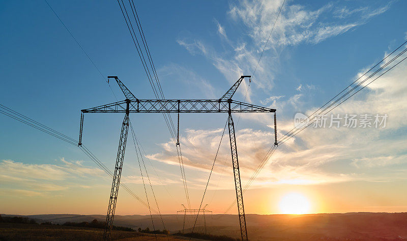 日落时的高压电线塔。电力传输