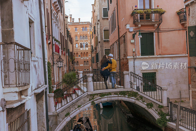 一对情侣在旧城大运河上的拱形人行桥上接吻