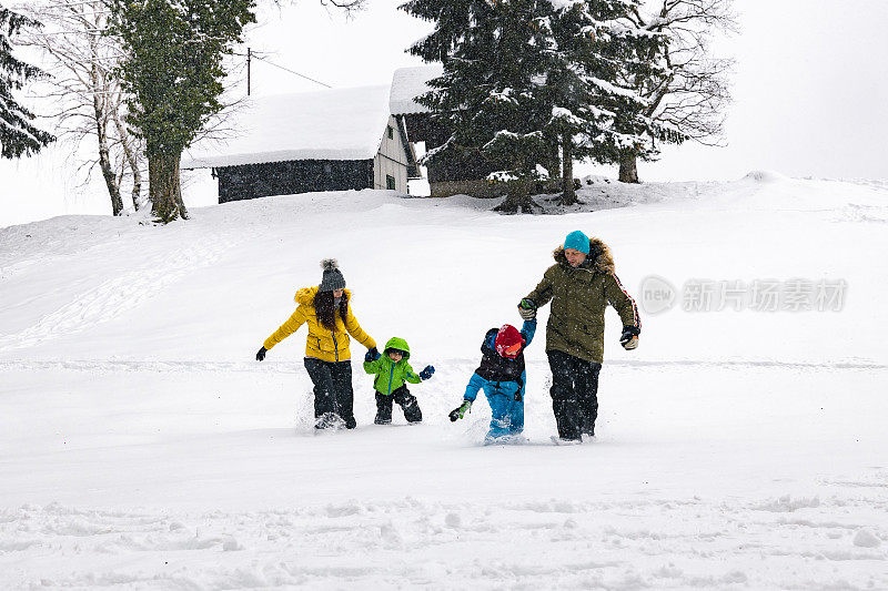 一家人带着两个孩子在雪地里享受美好的一天