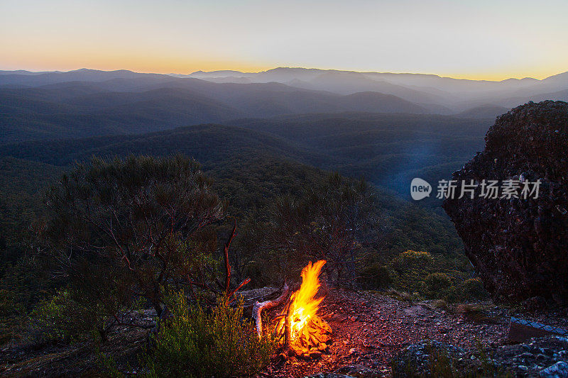 山间营火与起伏的景观背景