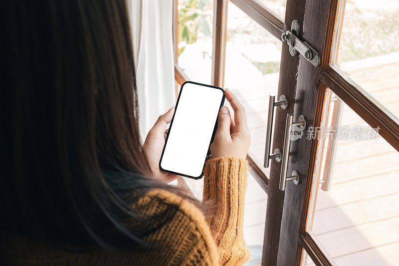女人手里的模拟手机显示白色屏幕。女人手里的模拟手机显示白色屏幕