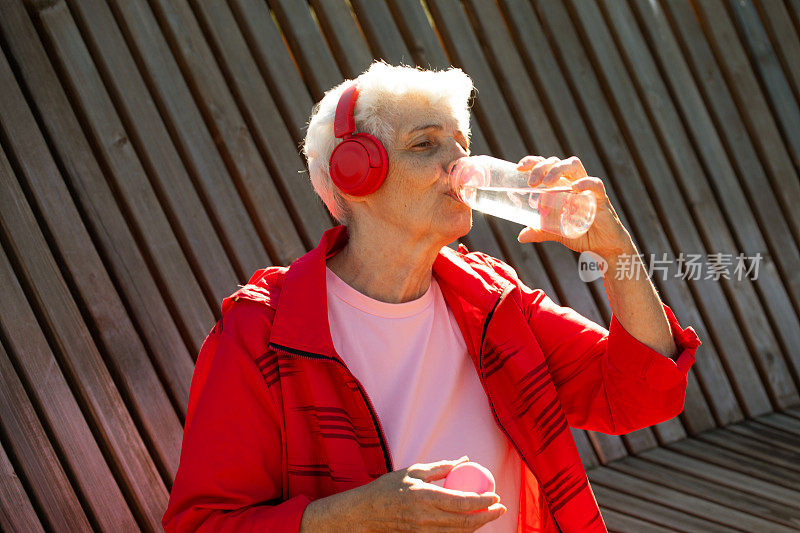灰白短发的老妇人在运动后喝水