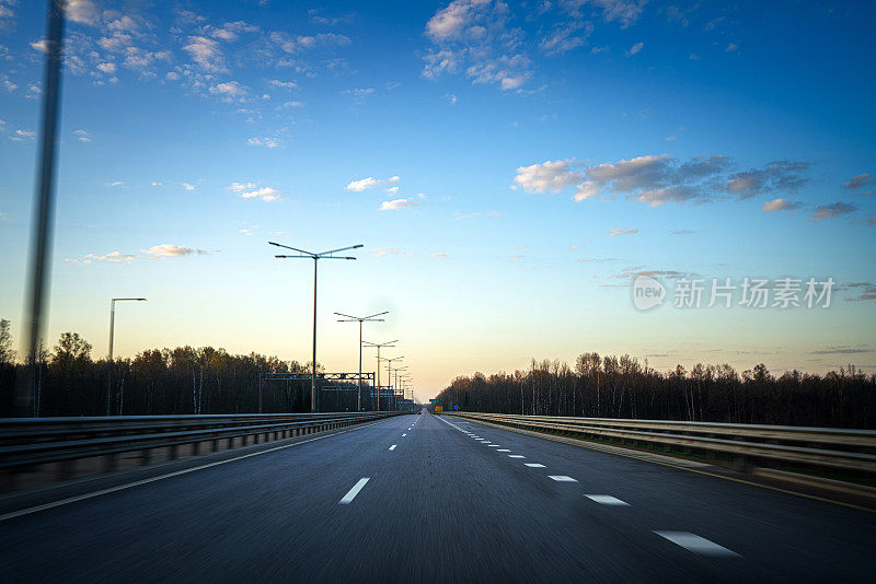 多车道的高速公路在傍晚，汽车的角度。放大效应