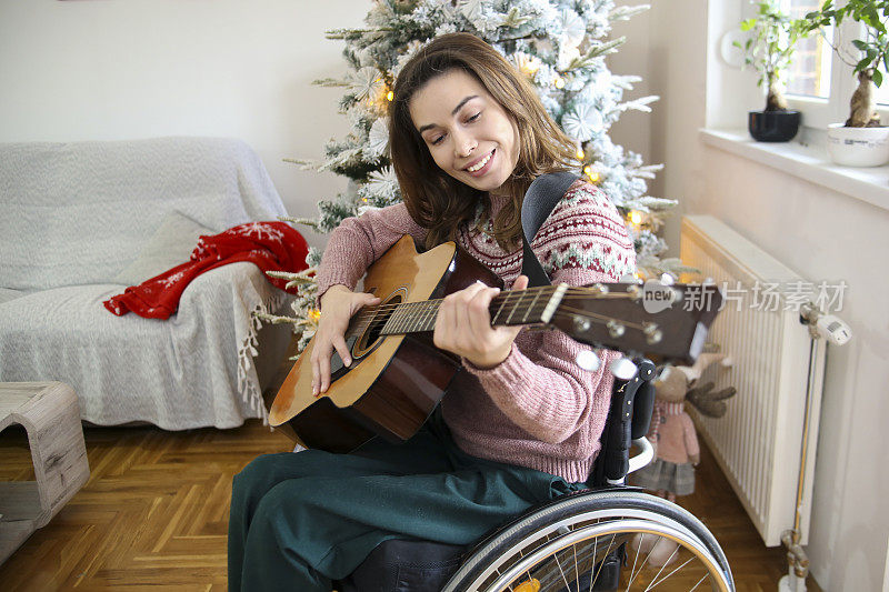 坐在轮椅上的女人在假期里弹吉他