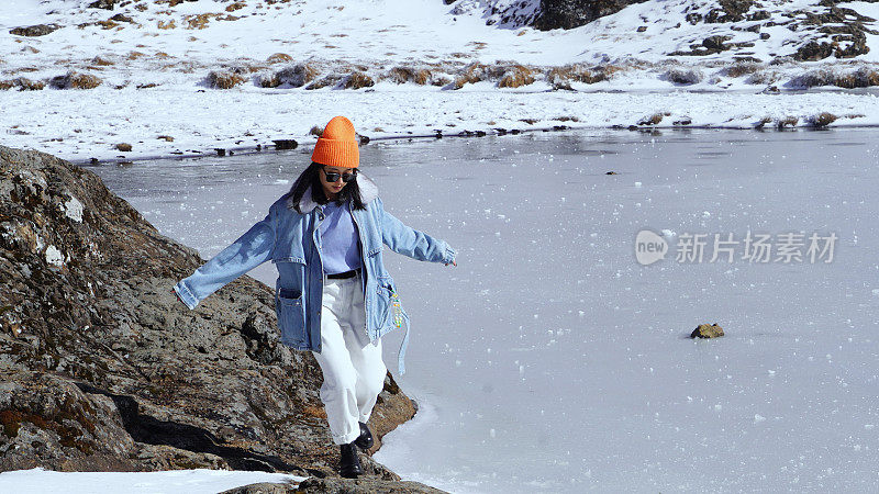 一个女人在寒冷的天气里穿行于白雪覆盖的山林之中