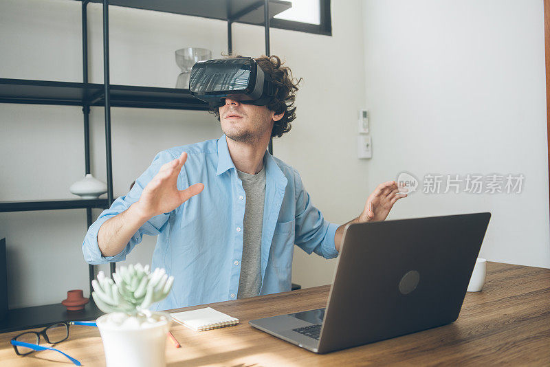 创意设计师兴奋地看着VR眼镜头显。拥有虚拟现实体验的人。玩电子游戏或模拟世界时触摸空气