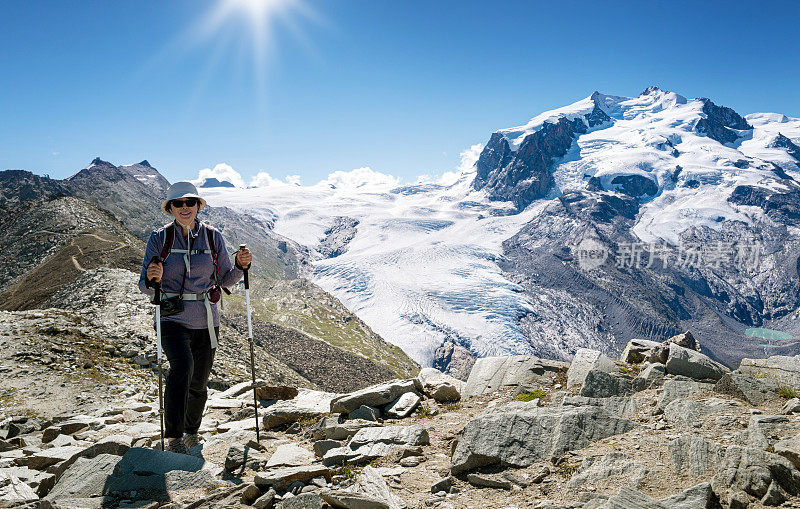 瑞士旅行——一位老年妇女在瑞士阿尔卑斯山的山脊上徒步旅行