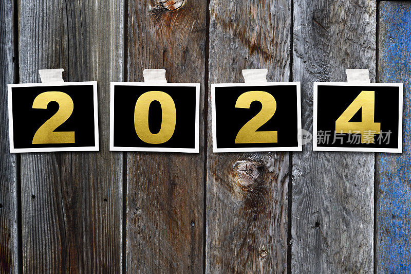 一排2024年新年的照片贴在旧木墙上