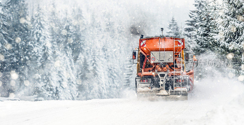 高速公路上的扫雪机。橙色卡车除冰街道。保养冬季磨砂车宽全景或横幅。