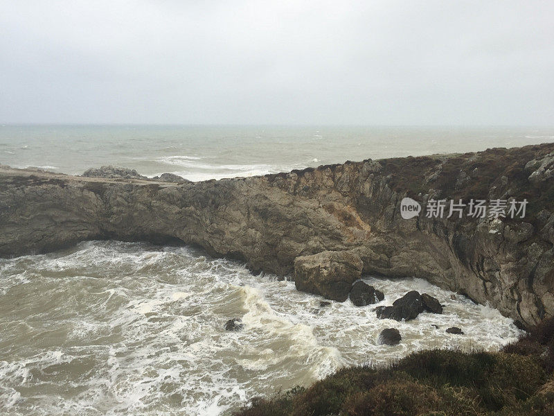 暴风雨天气中的海边悬崖。海岸线岩石，波涛汹涌的大海和多雨的天气背景