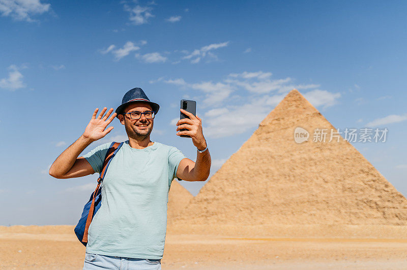 一个年轻人在开罗吉萨金字塔前进行视频通话