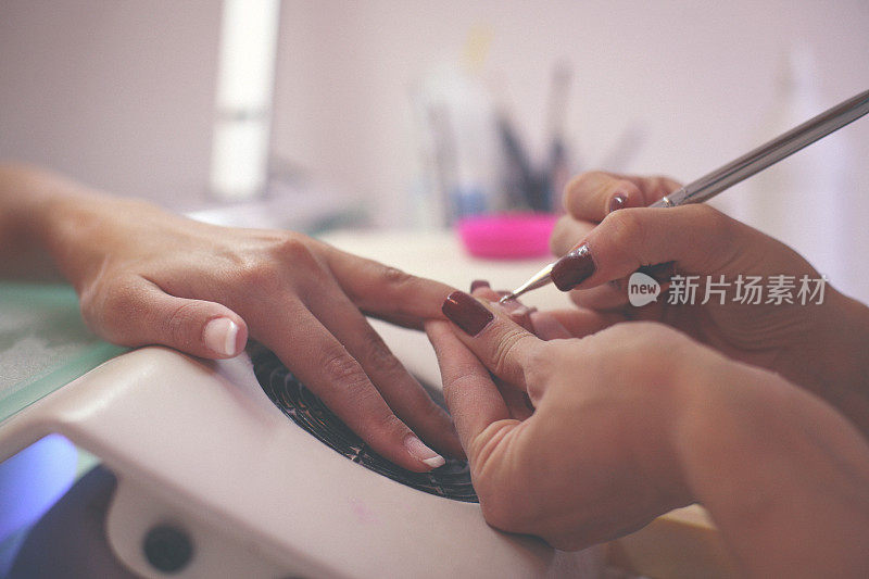 女性的手被修剪在美容院的特写。