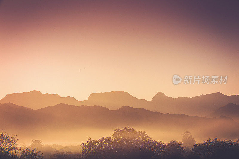 日出在海角酒乡清晨朦胧的剪影树和山宽的景象