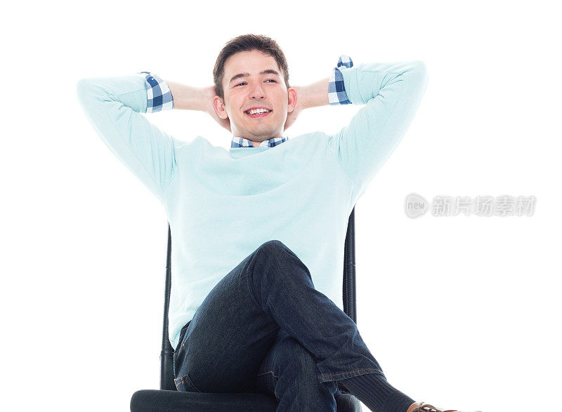 英俊的年轻人坐在椅背上，手放在脑后