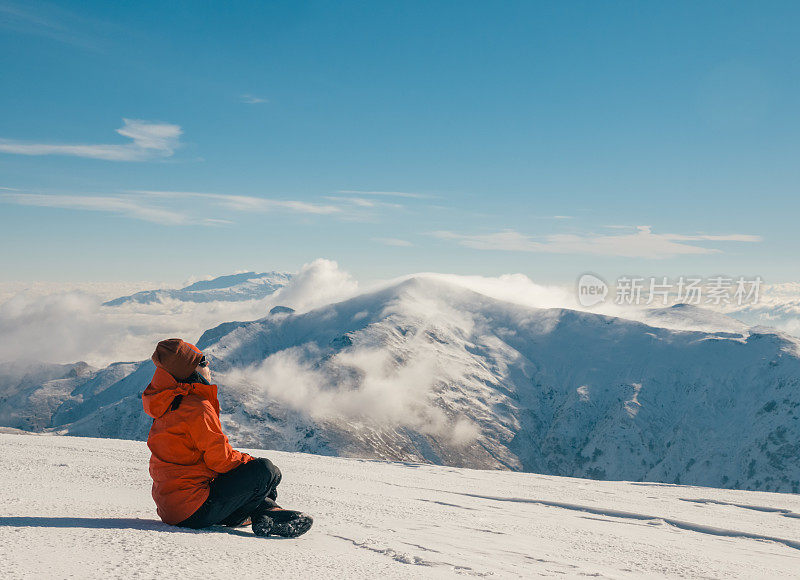 冬季，女性高山攀登者在山顶观赏风景