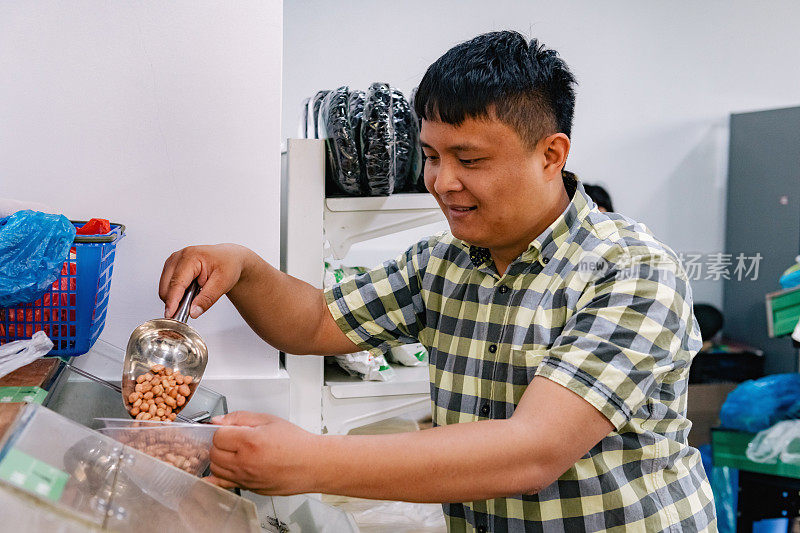 一名中国男子在市场摊位上挑选豆子