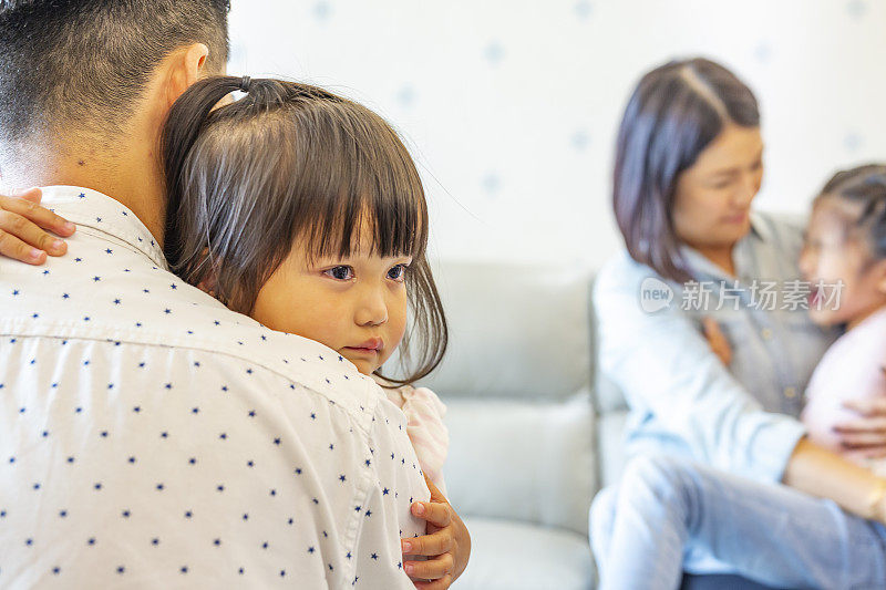 悲伤和哭泣的亚洲女孩被他们的父母安慰