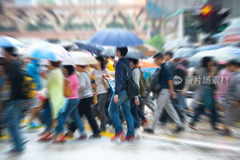 在雨中穿过香港街道的行人的动作模糊了