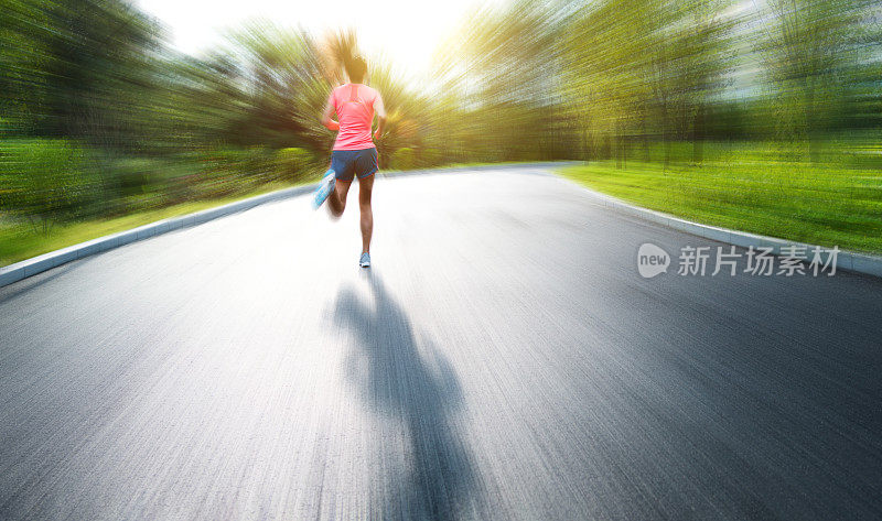 年轻的亚洲女人在公园慢跑