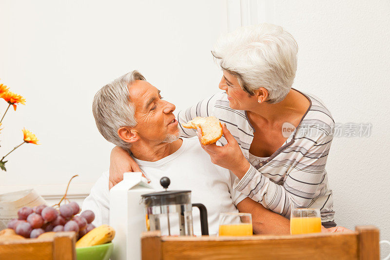 一对快乐的老年夫妇正在吃早餐