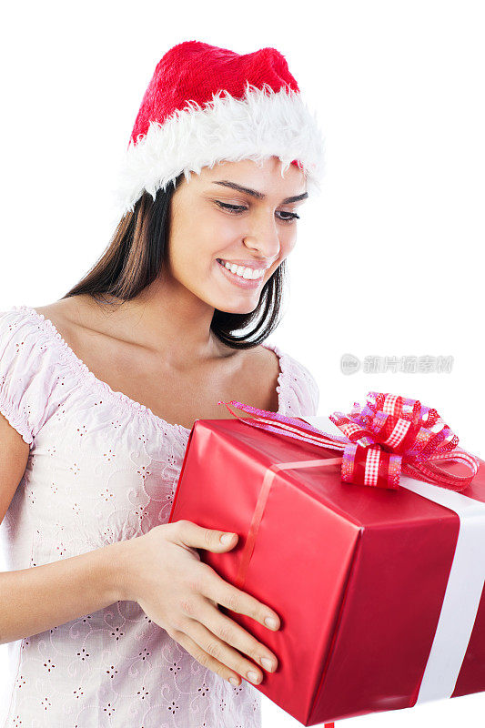 漂亮的女人拿着圣诞老人帽的圣诞礼物。