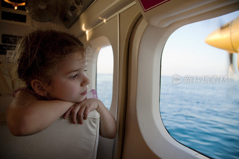 小女孩从水上飞机的舷窗往外看