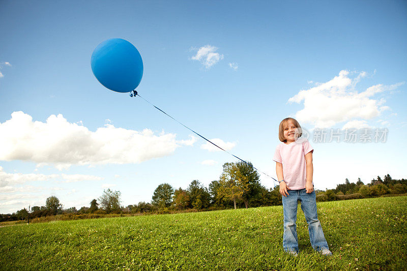 快乐的小女孩在外面拿着气球