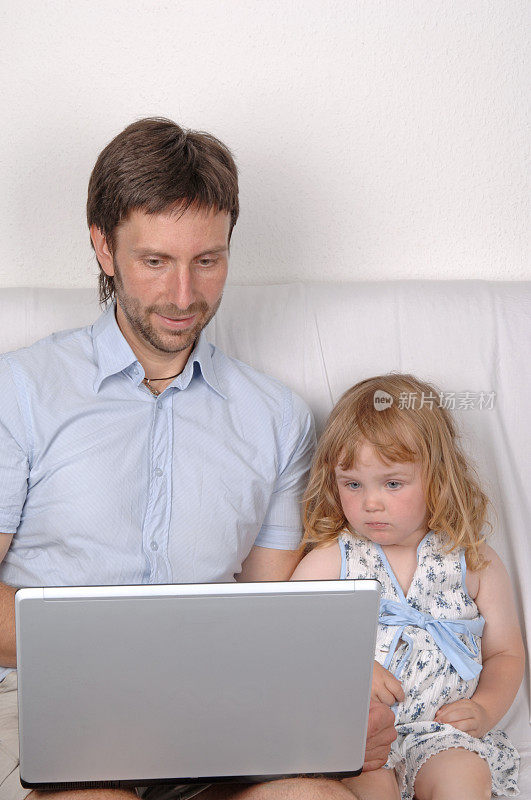 父亲和女儿用笔记本电脑