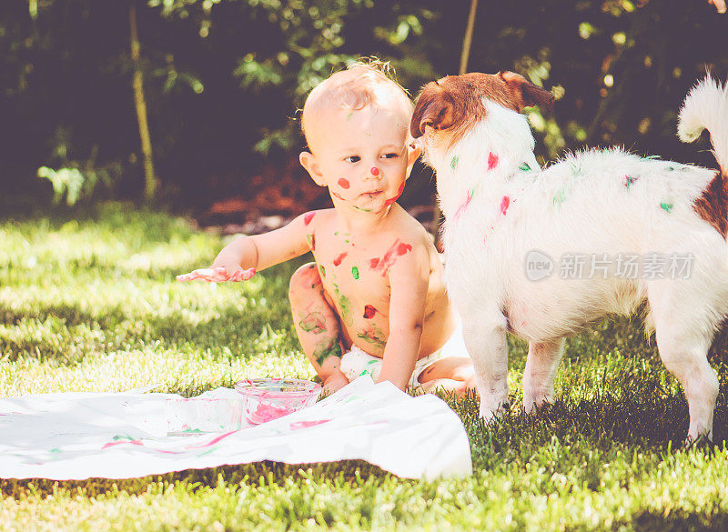 1岁的婴儿在自己身上和狗身上画画
