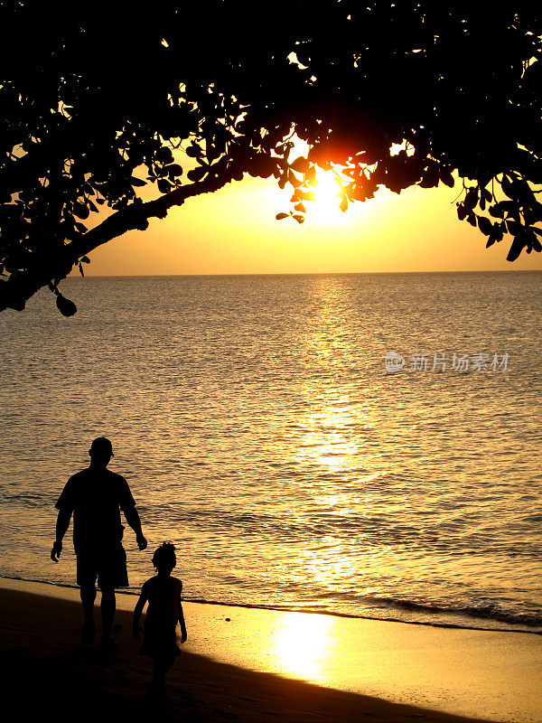 夕阳西下的海滩上父女的剪影