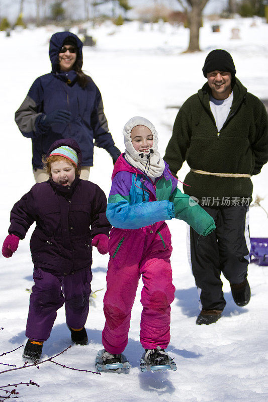 多民族家庭在雪中嬉戏奔跑