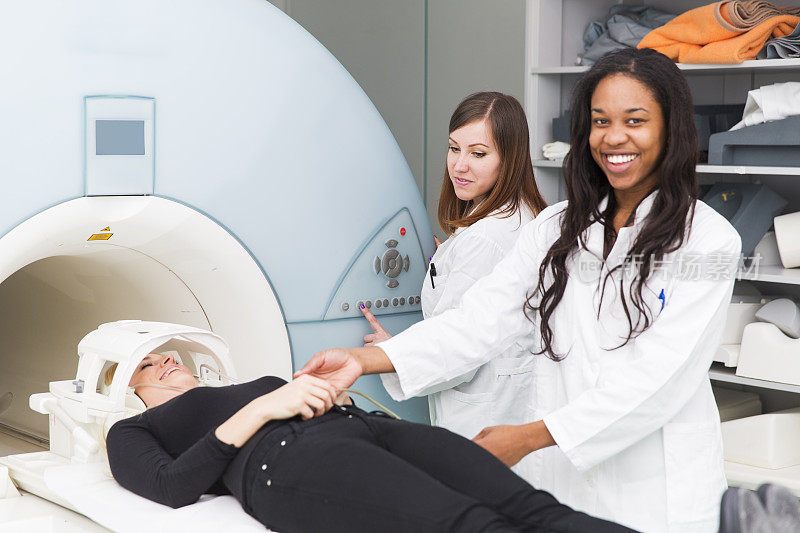 MRI扫描的女性，黑人技术员和她的同事帮助