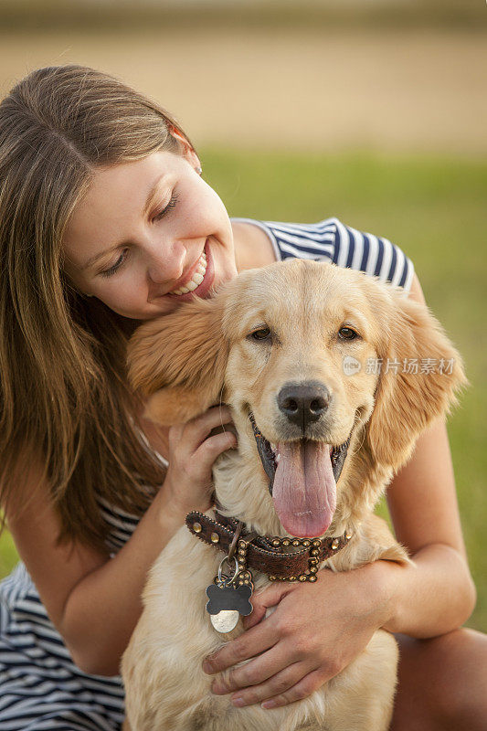 迷人的年轻女人和她的金毛猎犬