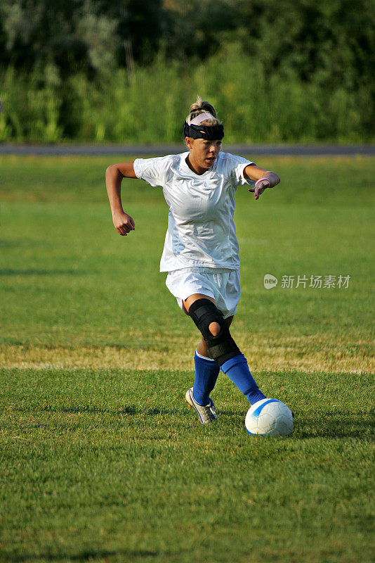 带护膝的女子足球运动员开始开球
