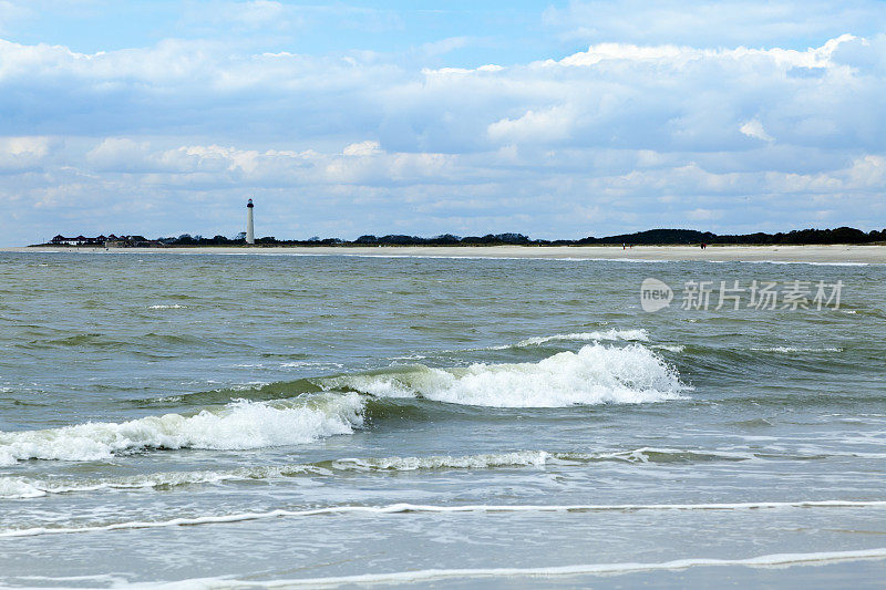 海浪与灯塔在长长的沙滩沙滩延伸
