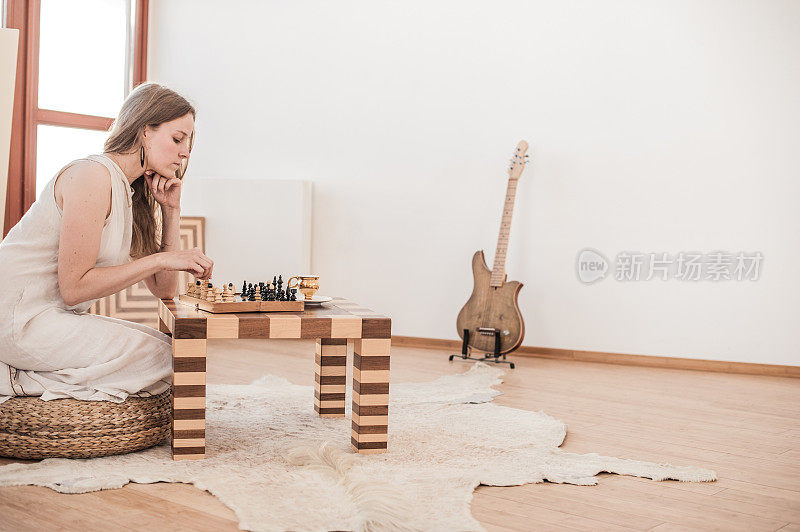 迷人的年轻女子在客厅下棋