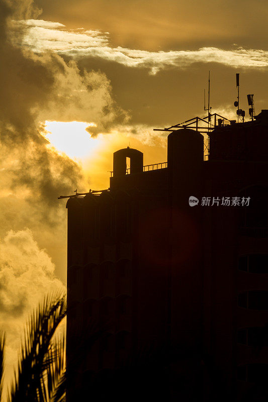 太阳在建筑和云彩后面升起