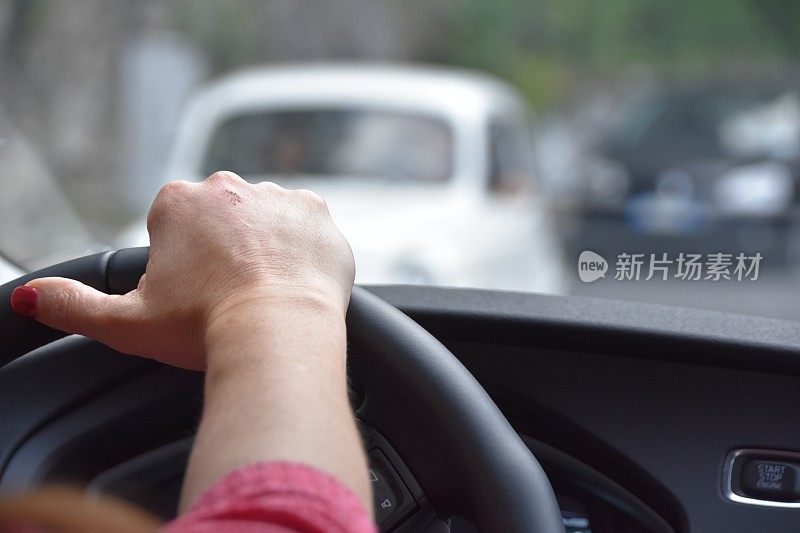 一个女人在一条狭窄的路上开车