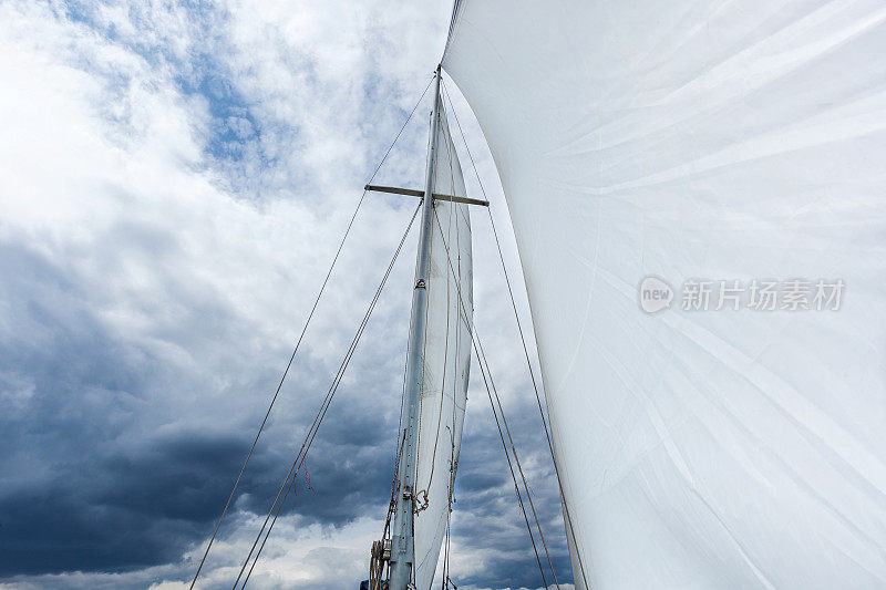 白色的帆映衬着多云的天空
