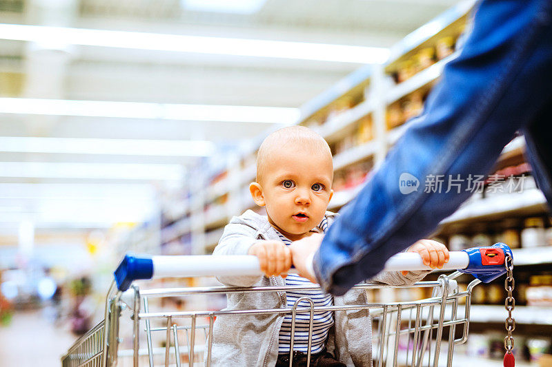 年轻的母亲和她的小男孩在超市。