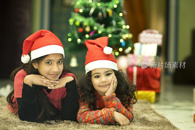 两个印度女孩戴着圣诞老人的帽子