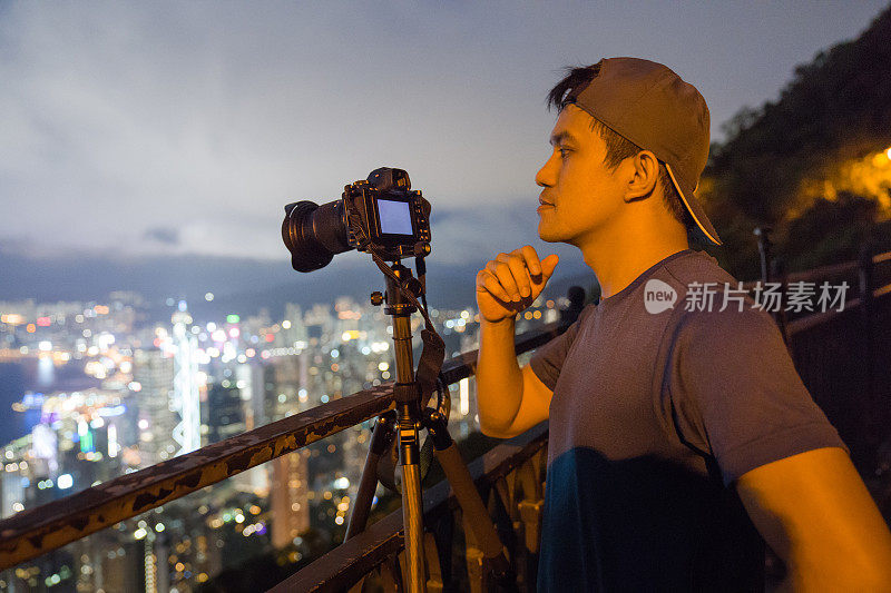 年轻的亚洲游客冒险拍摄香港的城市天际线在香港的famaus旅游胜地维多利亚峰