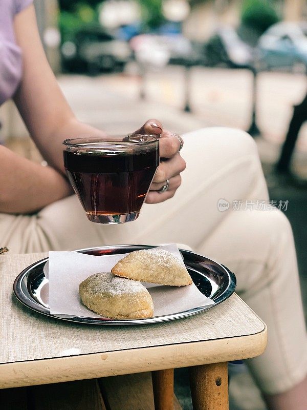 一个女人在咖啡馆里拿着一杯茶