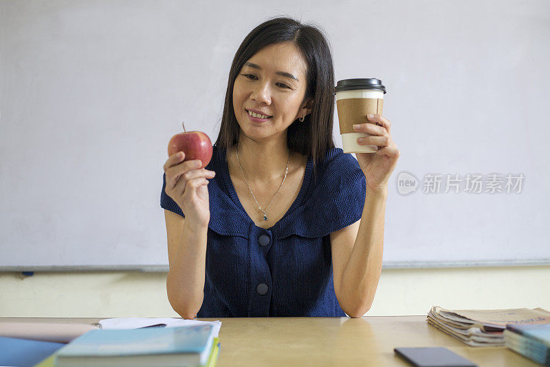 亚洲女性在办公桌前吃健康午餐