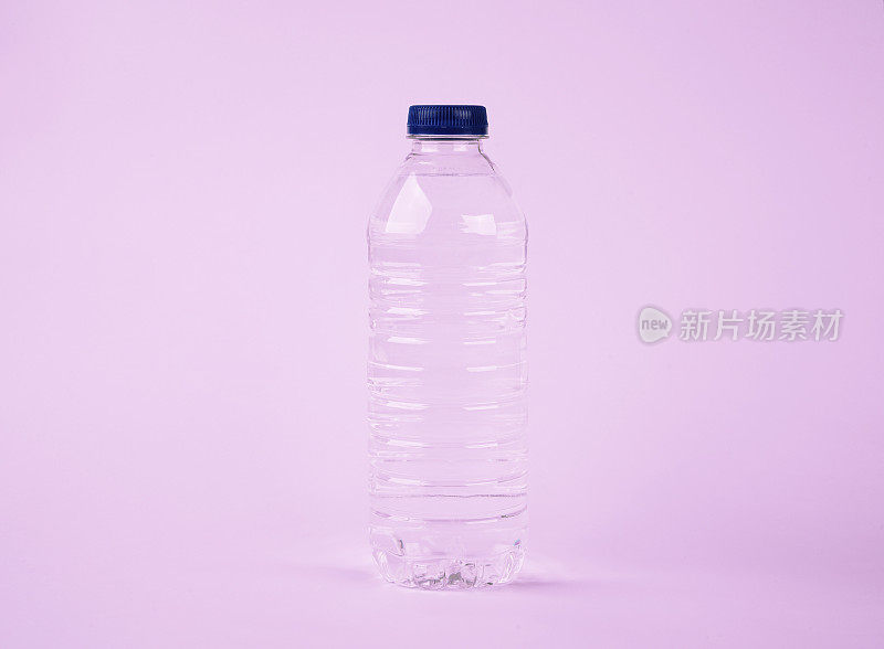 塑料瓶中的水在孤立的粉红色背景上