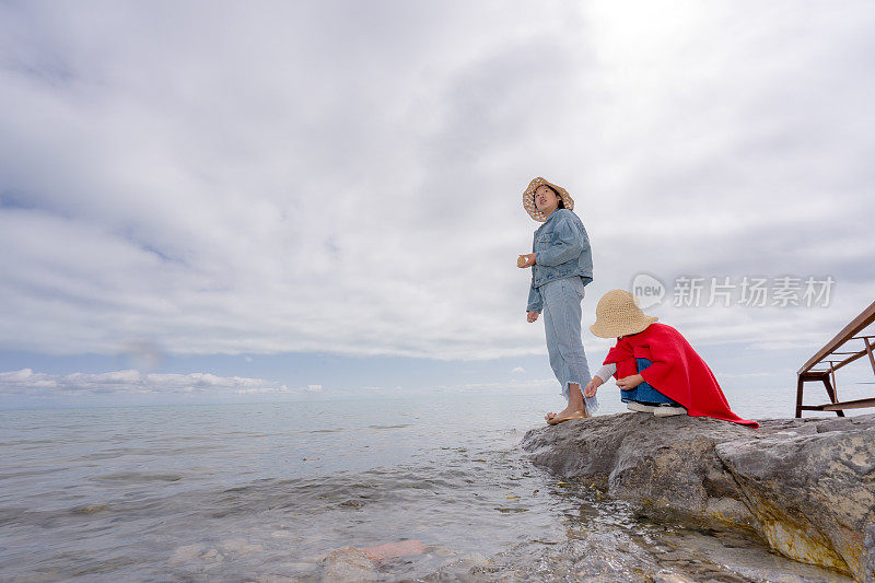 两姐妹在湖边喂鱼